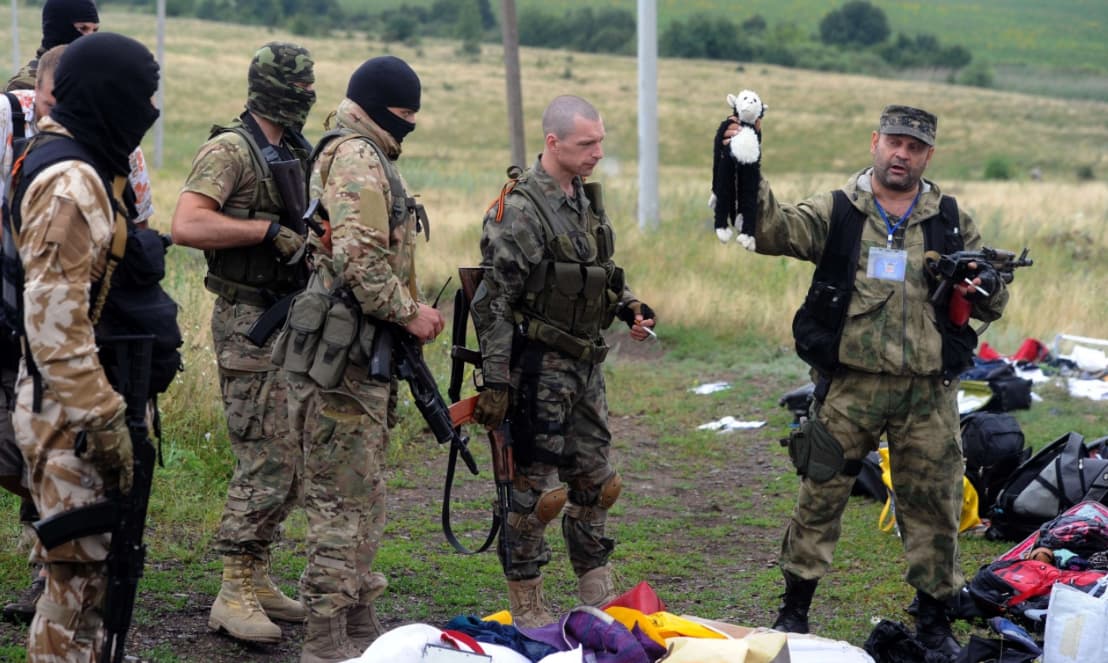 Ukrainos sukilėliai Malaisia Airlines reiso MH370 katastrofos vietoje. Karys laiko rankose vaikišką žaislą, rastą tarp lėktuvo keleivių daiktų.
