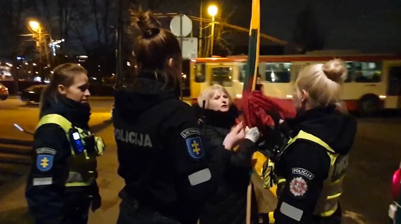 Policininkė išplėšė iš moters rankų vėliavą ir įmetė į policijos automobilį.