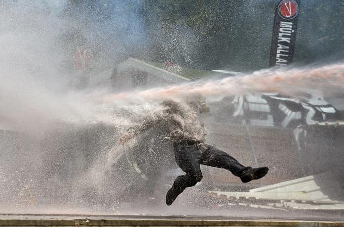 Paveiktas vandens patrankos žmogus akimirkai gali pajusti lengvą nesvarumo būseną, todėl noras protestuoti kuriam laikui nuslopsta. Nuotr. aljazeera.com