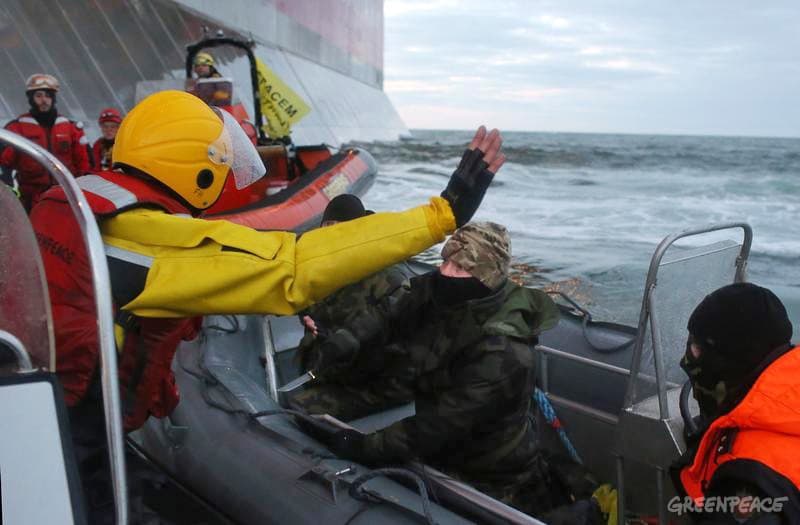 Rugsėjo 18 d. sulaikant Greenpeace aktyvistus, „Gazprom” apsaugininkas ginklu grasina gamtosaugininkui. Nuotr. Greenpeace